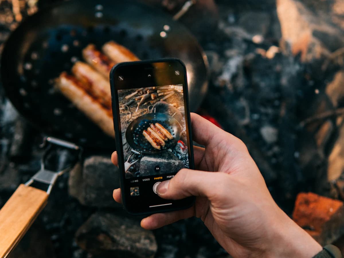 Photographing campfire cooking on a phone