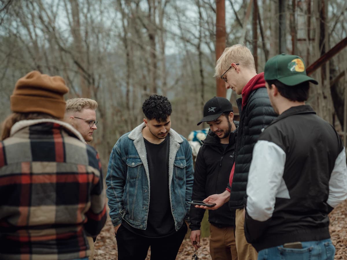 Friends in the woods gathered around a phone